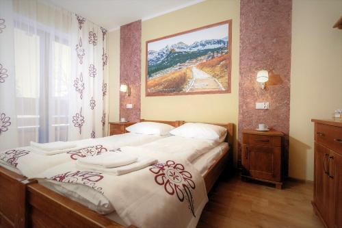 a bedroom with two beds and a painting on the wall at Dom Wczasowy Na Szczycie in Zakopane