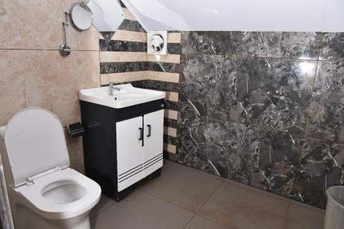 a bathroom with a white toilet and a sink at GOLDEN GREEN RESORT WITH Pool in Munnar