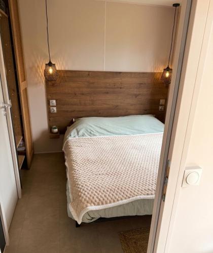 a bed in a room with two lights on it at Prins Chalets Hoogersmilde Drenthe in Hoogersmilde