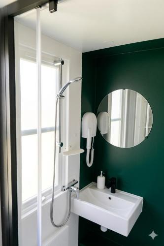 a green bathroom with a sink and a mirror at Prins Chalets Hoogersmilde Drenthe in Hoogersmilde