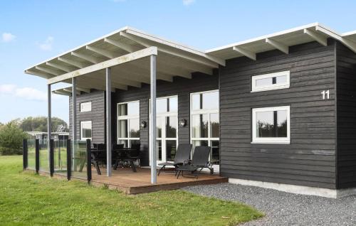a black house with a porch and a deck at Awesome Home In Haderslev With Sauna in Haderslev
