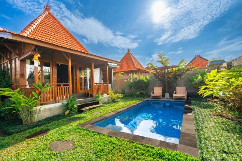 a villa with a swimming pool in front of a house at Shankara D'Uma in Ubud
