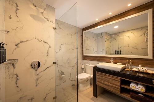 a bathroom with a shower and a sink and a toilet at Bali Dynasty Resort in Kuta