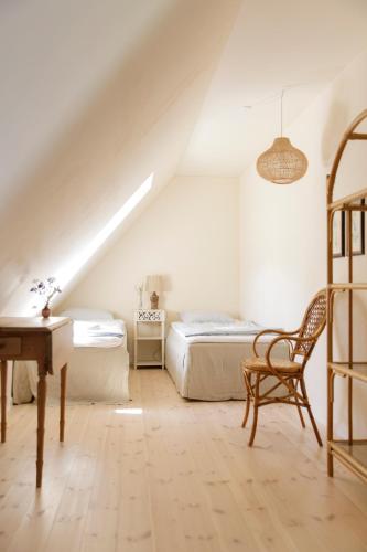 a attic bedroom with two beds and a desk at Atma Guesthouse - cozy and simple farmhouse bed & breakfast in Marstal