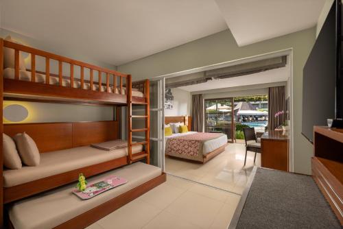 a bedroom with two bunk beds and a living room at Bali Dynasty Resort in Kuta