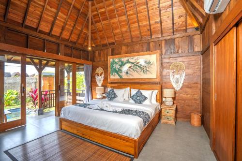 a bedroom with a bed in a room with wooden walls at Shankara D'Uma in Ubud