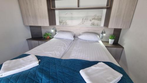 a large bed in a room with a window at Srebrna Wydma in Dąbki