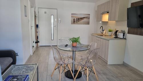 a kitchen with a table and chairs in a room at Srebrna Wydma in Dąbki