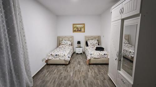 a room with two beds and a mirror at Spacious accommodation with city views in Haï Khemisti