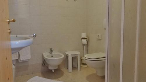 a bathroom with a toilet and a bidet and a sink at Hotel Giardino in Bormio