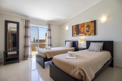a hotel room with two beds and a window at Villa Vista by Algarve Holidays in Valados