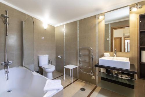a bathroom with a tub and a toilet and a sink at Villa Vista by Algarve Holidays in Valados