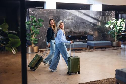 two women walking with their luggage in a lobby at Van Der Valk Hotel Zwolle in Zwolle