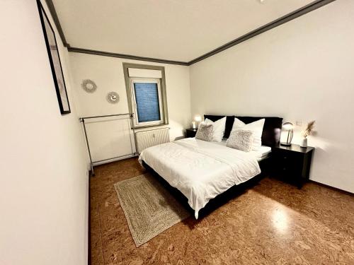 a bedroom with a bed with white sheets and a window at Charmante Wg im Stadtgeflüster in Schwäbisch Hall