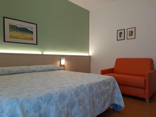 a bedroom with a bed and a red chair at B&B Locanda Al Pontesel in Garda