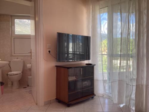 a bathroom with a tv and a toilet in a room at Soft Horizon Apartment in Loutraki