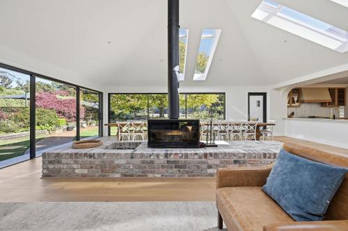 a living room with a brick fireplace in a house at Snowline - Ultimate Getaway, Pool, Spa & Tennis in Canobolas