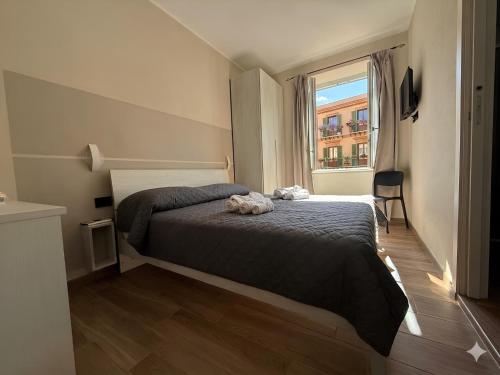 a bedroom with a bed and a large window at La Rosa dei Venti in SantʼAntìoco