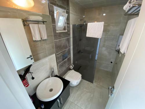 a small bathroom with a sink and a shower at Arya Apart Kundu Hotel in Lara