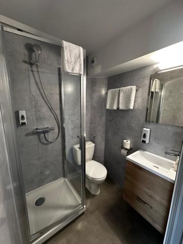 a bathroom with a shower and a toilet and a sink at Fasthotel Laval in Laval