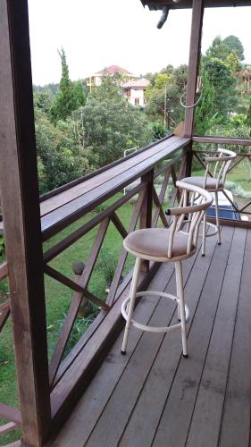 two chairs sitting on a wooden deck with a view of a field at Villa Diantie in Bogor