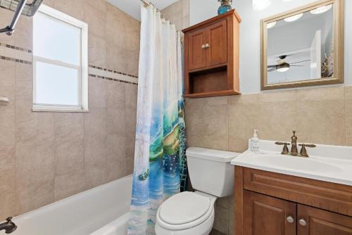 a bathroom with a toilet and a sink and a mirror at Flagler Suites 2 in New Smyrna Beach