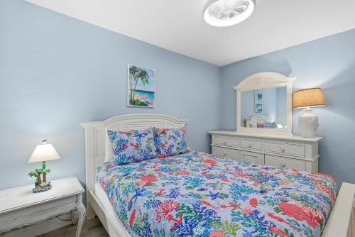 a bedroom with a bed and a dresser and a mirror at Flagler Suites 4 in New Smyrna Beach