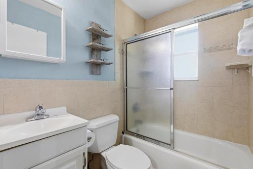 a bathroom with a shower and a toilet and a sink at Flagler Suites 4 in New Smyrna Beach