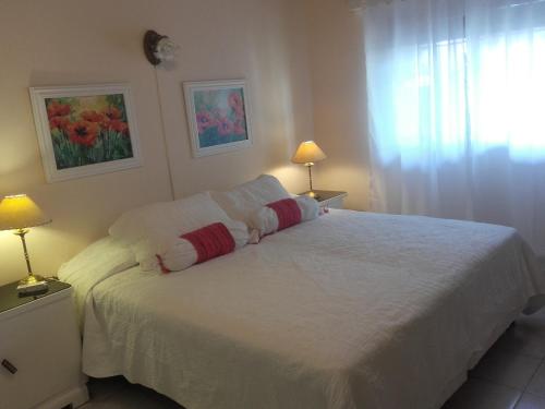 a bedroom with a white bed with two pillows on it at Las Acacias De Santa Rosa in Santa Rosa
