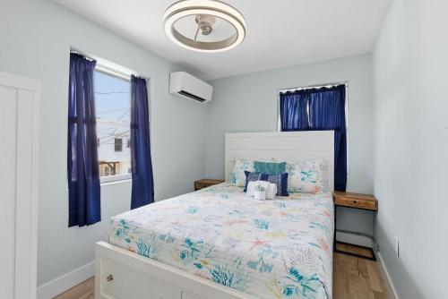 a bedroom with a bed with blue curtains at Flagler Suites 1 in New Smyrna Beach