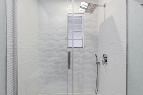 a shower with a glass door in a bathroom at Flagler Suites 1 in New Smyrna Beach