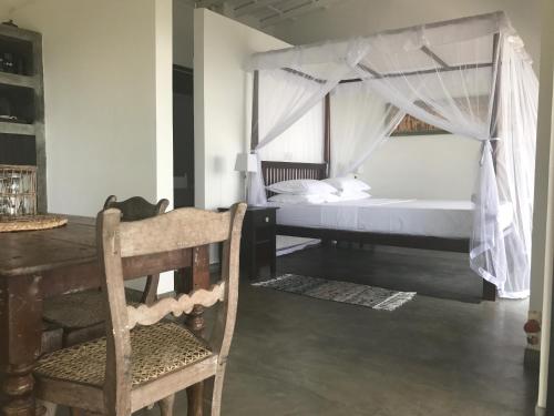 a bedroom with a bed and a table and a chair at Lara's place in Unawatuna