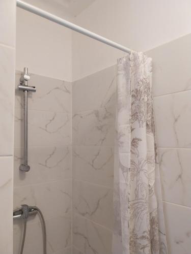 a shower with a shower curtain in a bathroom at Bienvenue chez Rosa in Vila Real de Santo António