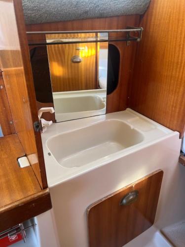 a small bathroom with a sink and a mirror at Nuit insolite sur un bateau in Cap d'Agde