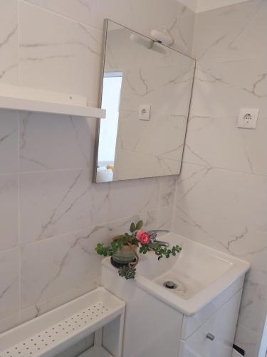 a white bathroom with a sink and a mirror at Bienvenue chez Rosa in Vila Real de Santo António