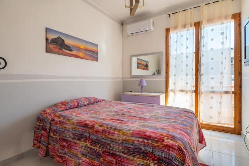 a bedroom with a bed and a window at Piccola Casa Melis in Capoterra