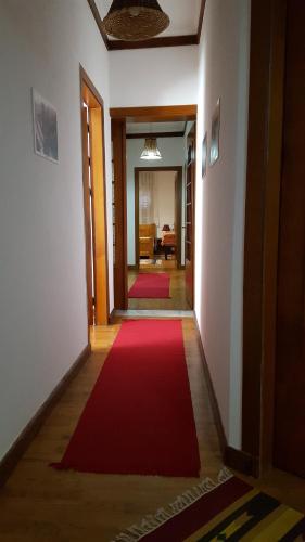 a hallway with a red rug on the floor at Hotel Bujtina e Bardhe in Korçë
