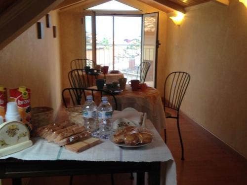stół z talerzem z jedzeniem i butelkami wody w obiekcie B&B Dalle Zie w mieście San Pietro a Maida