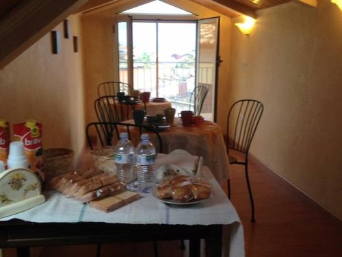 - une table avec une assiette de bouteilles d'eau et de nourriture dans l'établissement B&B Dalle Zie, à San Pietro a Maida