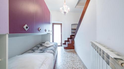 a bedroom with a bed and a purple wall at La Casa Di Nicole by Rentbeat in Polignano a Mare