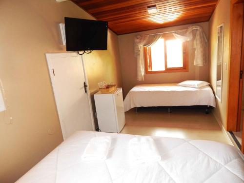 a small bedroom with two beds and a window at Apartamentos Sulla Collina Centro de Gramado localizado próximo da rua Coberta in Gramado