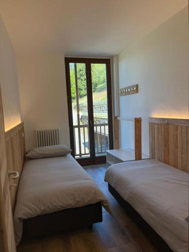 two beds in a room with a window at Seandre Holiday Apartments in Prada