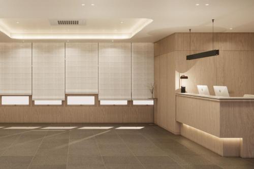 a lobby with a waiting area with white chairs at UH Suite The Seolleung in Seoul