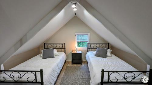 two beds in a attic bedroom with a roof at Le Chalet de la Combe Sainte-Anne in Selongey