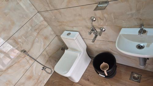 a bathroom with a white toilet and a sink at Grace place in Vagamon