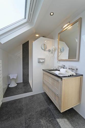 a bathroom with a sink and a mirror at Hotel des Ardennes in Corbion