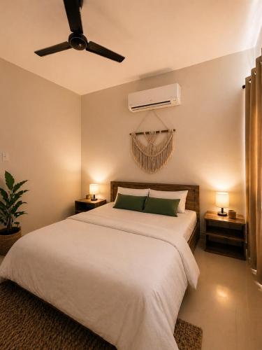 a bedroom with a white bed with a ceiling fan at Live Easy in Siliguri