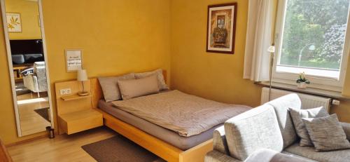 ein kleines Zimmer mit einem Bett und einer Couch in der Unterkunft FERINO - zentral & ruhig - Glasfaser WLAN & LAN - privater Parkplatz in Gütersloh