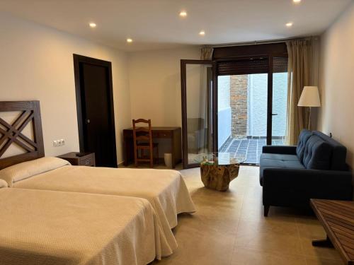 a hotel room with a bed and a couch at Hostal Mulhacén in Trevélez