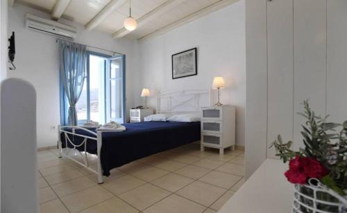 a bedroom with a blue bed and a window at GLAFKY Retreat in Panormos
